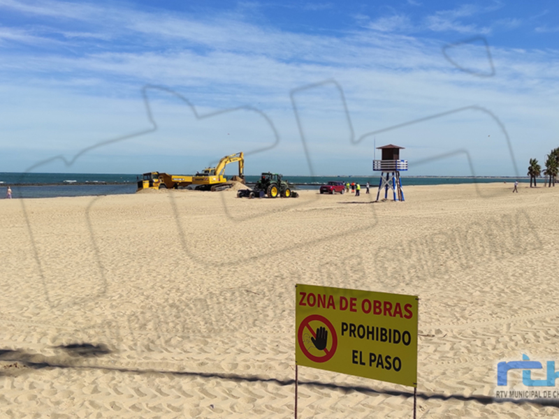 Zona de obras en la playa con máquinas de construcción y señalización prohibiendo el paso.