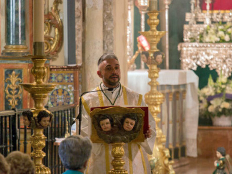 Elegante altar con flores y una figura religiosa en un entorno de iglesia.