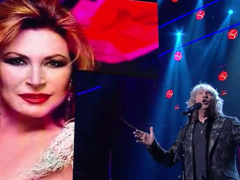 Una imagen dividida en dos: una parte superior con una mujer con cabello rojo y maquillaje dramático, y una parte inferior con un hombre en un escenario de concierto con luces y efectos visuales.