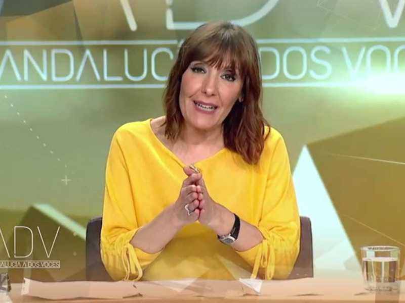 Una presentadora de televisión en un programa informativo, con un fondo gráfico brillante y la palabra 'ANDALUCIA' en la pantalla.
