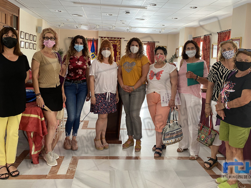 Gruppo di donne in una sala con mascherine, posa per una foto ufficiale.