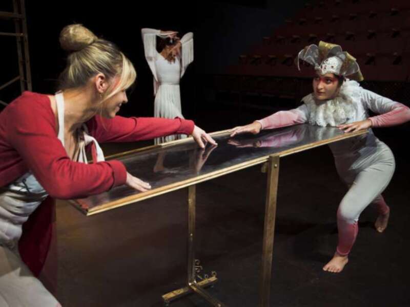 Danzas contemporáneas en escenario con actores interrumpiendo una mesa de cristal.