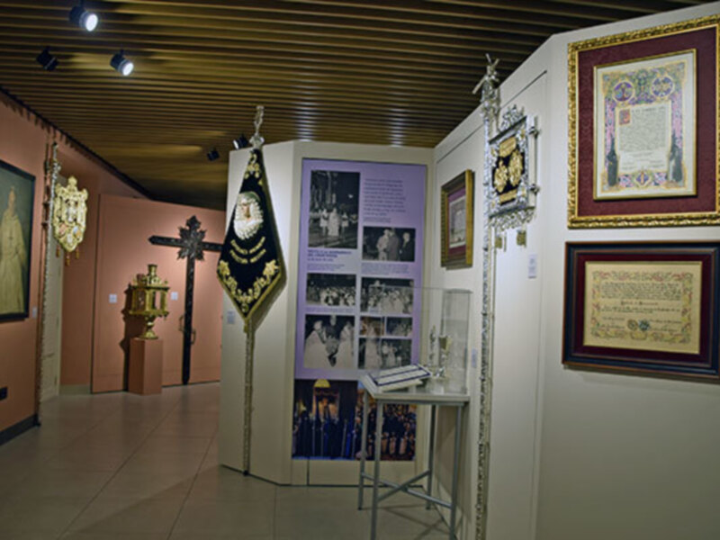 Exposición histórica con objetos religiosos y documentos enmarcados.