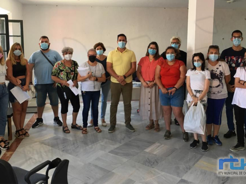 Una reunión de trabajo en un espacio moderno, con personas vestidas formalmente y usando mascarillas, posiblemente en un entorno de oficina o centro de atención al público.