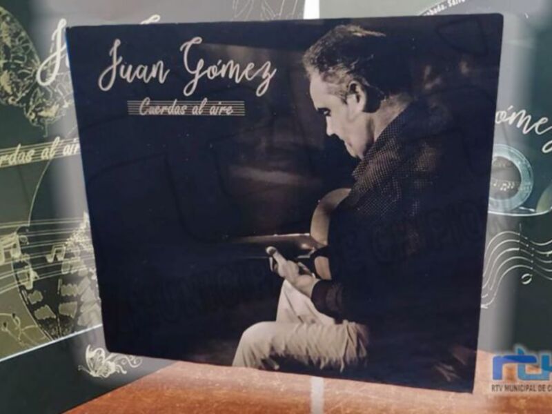 Portada del álbum 'Cuerdas al aire' de Juan Gómez, un músico tocando la guitarra en un ambiente acústico.