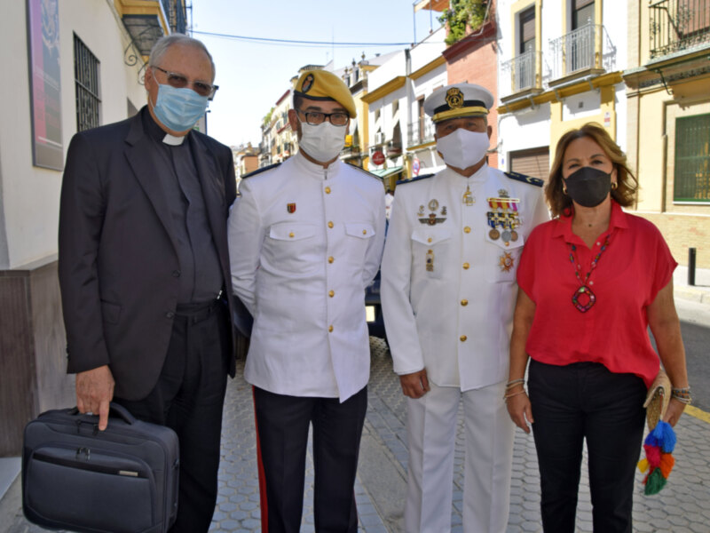 Personajes en uniforme y vestimenta formal posan juntos en una calle urbana.