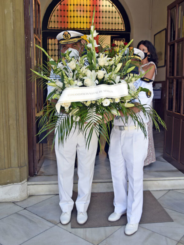 Oficiales de la Armada de España llevan un ramo de flores en una ceremonia oficial en la Comandancia Naval de Sevilla.