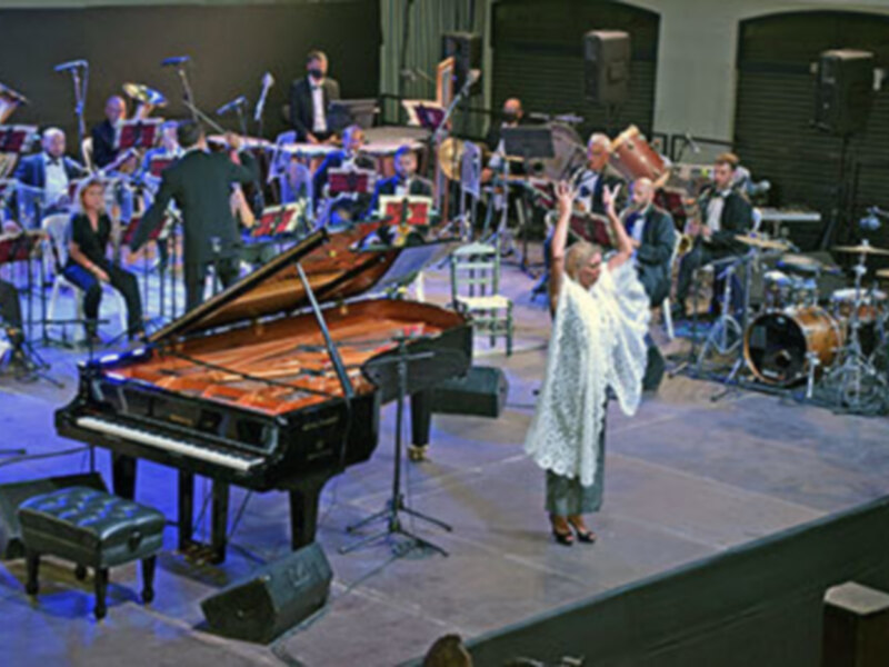 Concierto de jazz con pianista y bailarina en escenario.