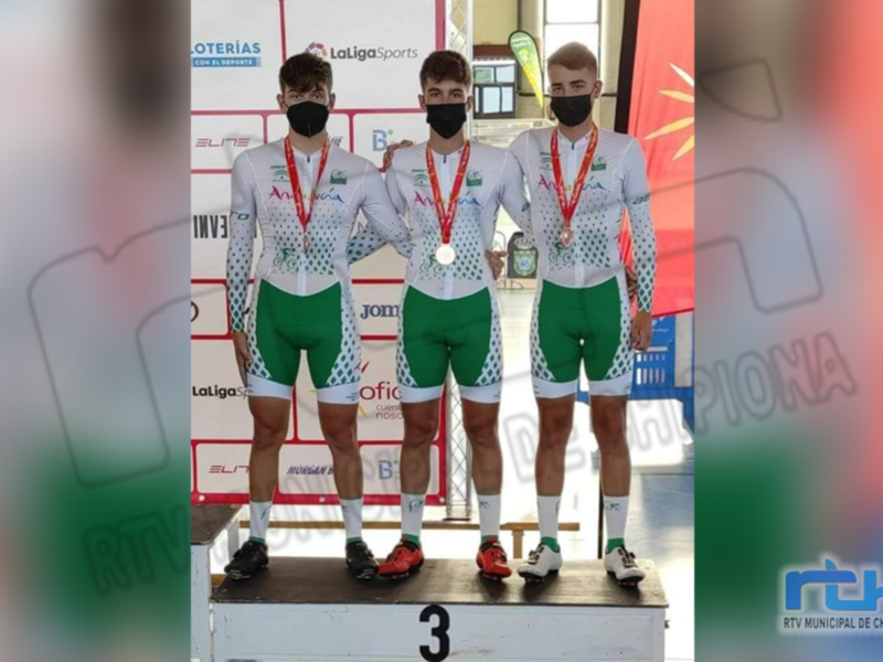 Tres ciclistas posan en el podio con sus medallas, destacando su victoria en una competición de ciclismo.