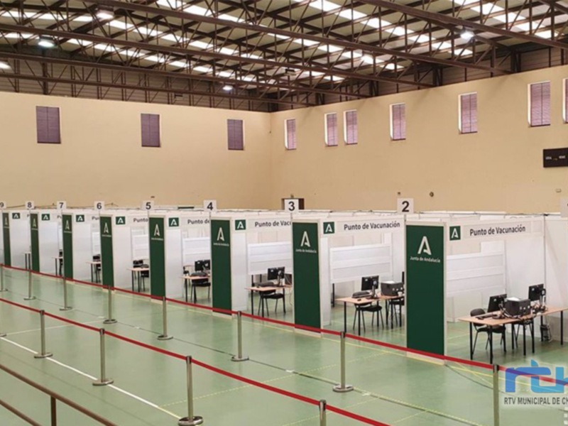Espacio de vacunación con estaciones numeradas y separadas por vallas verdes.