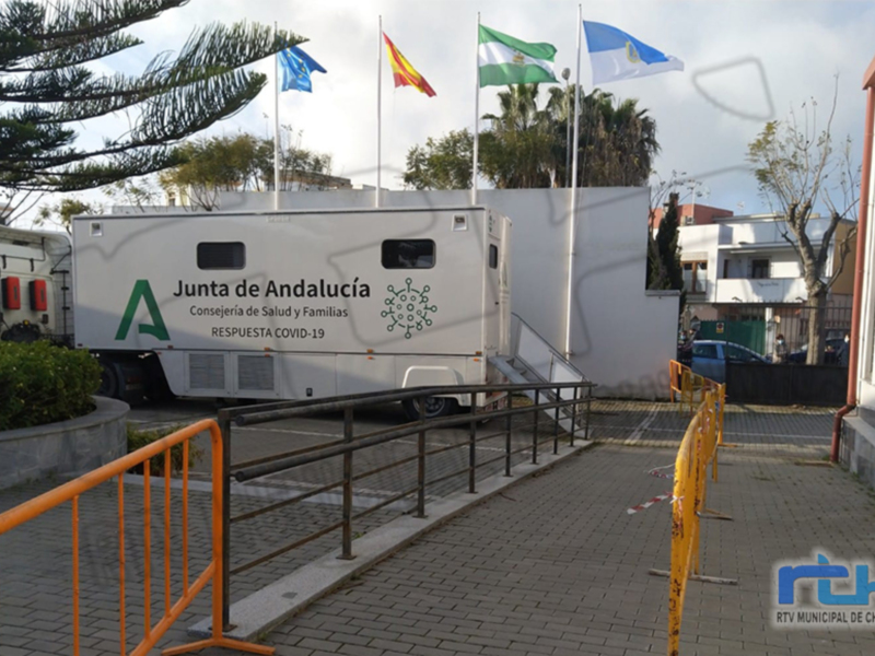 Un camión móvil de la Junta de Andalucía, Conserjería de Salud y Familias, destinado a la respuesta COVID-19, estacionado frente a un edificio municipal.