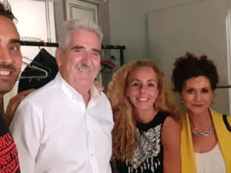 Cuatro personas sonrientes posando juntas en un entorno interno, probablemente en una tienda de ropa o un espacio comercial.