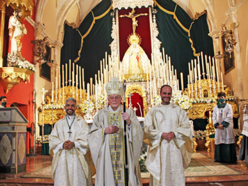 Celebración religiosa en iglesia con sacerdotes en trajes blancos y ornamentos dorados