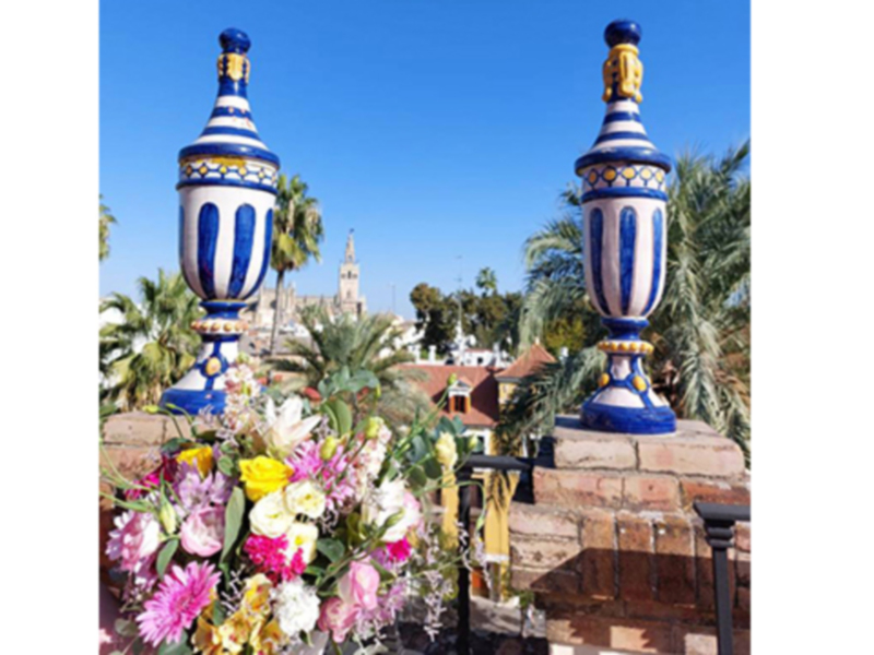 Pérgola de flores con detalles azules y blancos en el parque de la Alameda, Sevilla, España.