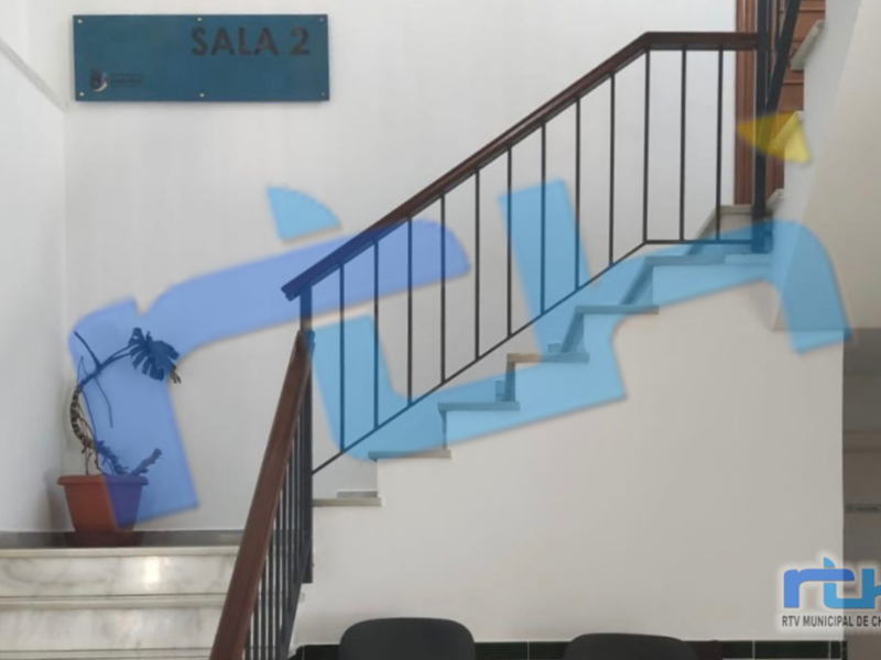 Interior view of Sala 2, a staircase leading to a second floor with a sign indicating the room number.