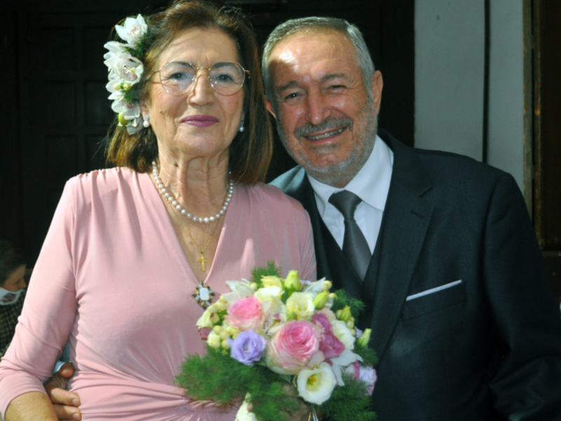 Feliz pareja celebrando un evento especial con flores y ropa formal.
