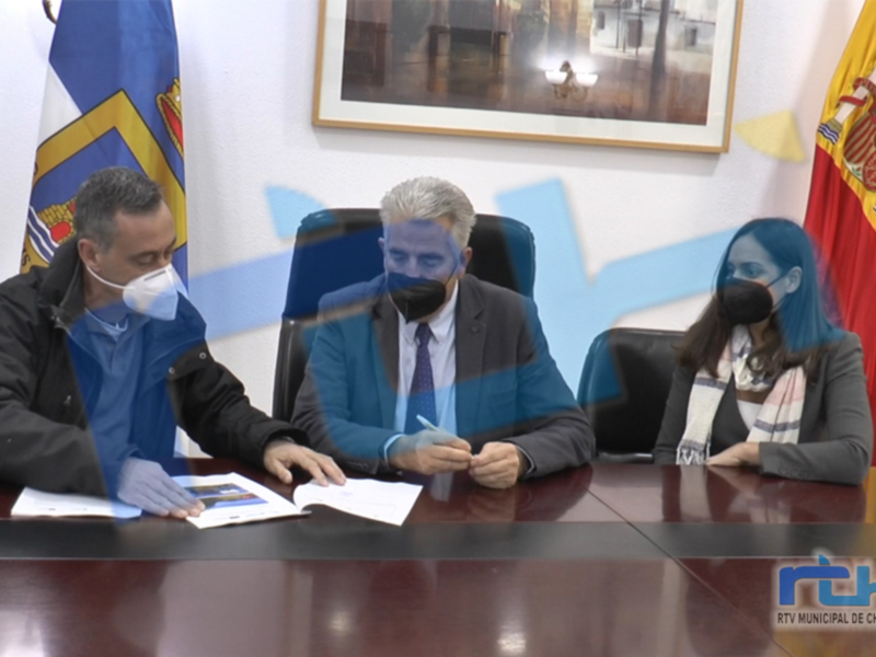 Reunión oficial en Chipiona con banderas y documentos firmados.