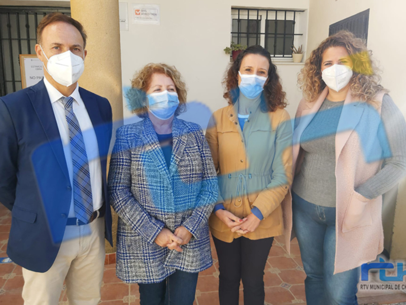 Equipo de profesionales con mascarillas en una reunión frente a un edificio municipal.