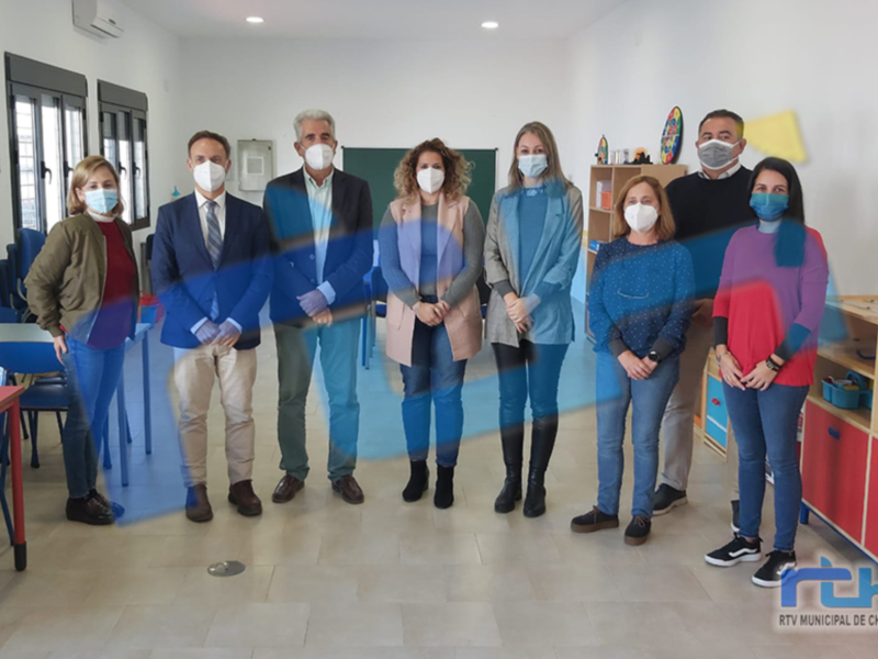 Equipo de profesionales y autoridades en una sala de aula, con mascarillas, posando para una foto oficial.