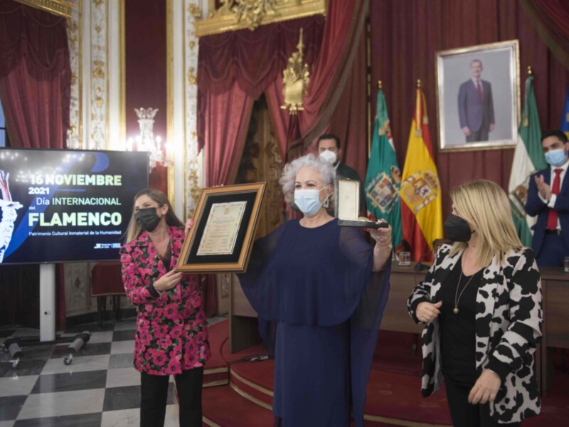 Celebración del Día Internacional del Flamenco 2021 en un salón con decoración clásica y banderas de España y Andalucía.