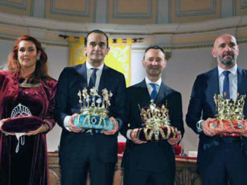 Premiación en un evento formal con coronas y vestimenta tradicional.