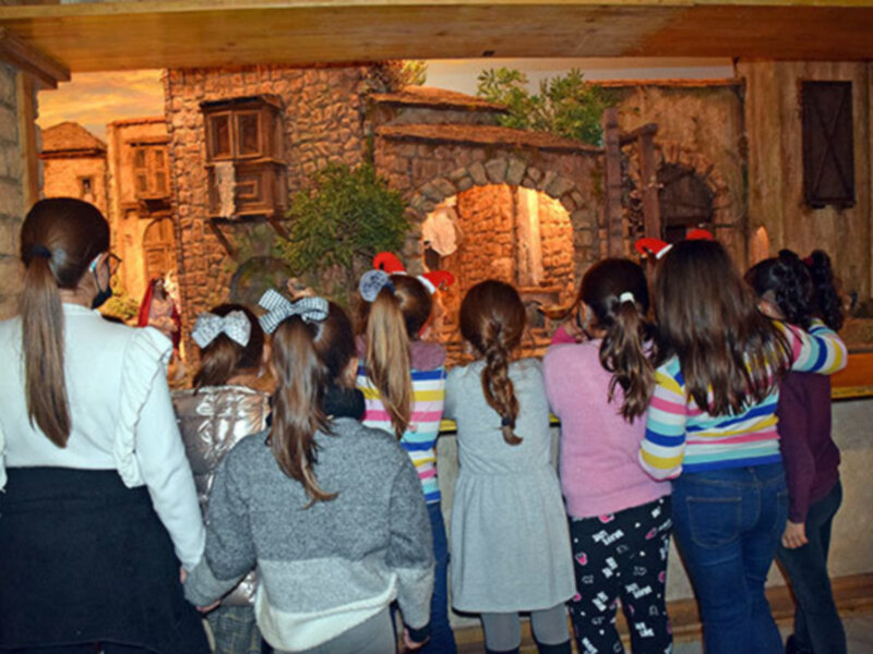 Un grupo de niños observa una escenografía histórica en un museo o centro educativo.