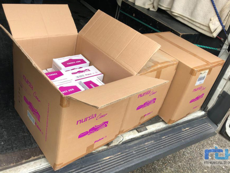 Cajas de cartón con la marca "Nursia" en el maletero de un vehículo.