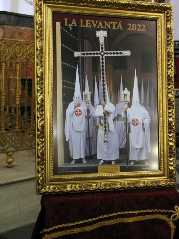 Procesión de la Levantantá 2022 en la Semana Santa, con hermanos vestidos de blanco y capas rojas.