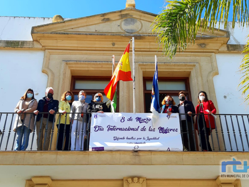 Celebración del Día Internacional de la Mujer en Chipiona, con autoridades municipales en el balcón del Ayuntamiento.