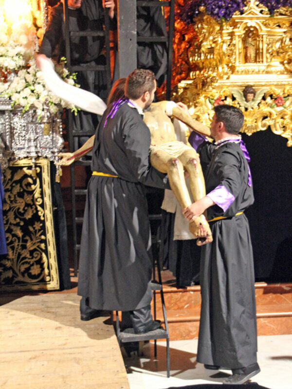 Misa de la Candelaria en la Catedral de Lima, Perú. Un sacerdote bendice a un crucifijo durante la celebración religiosa. La imagen muestra la solemnidad y la reverencia en este evento religioso.