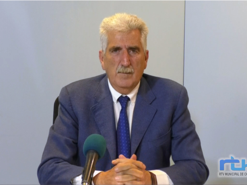 Hombre en traje azul hablando en una conferencia de prensa.
