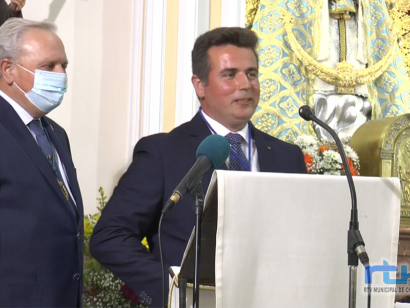 Hombre en traje hablando en un podium durante un evento formal en un entorno religioso.