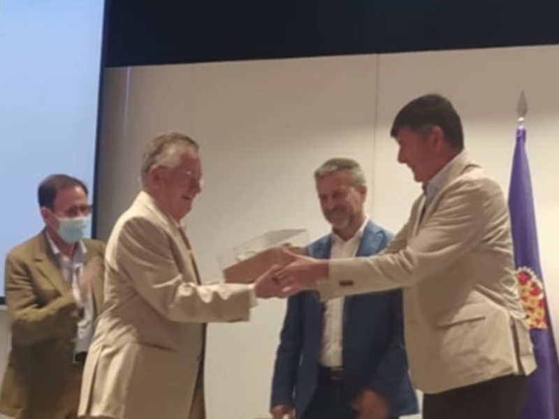 Entrega de reconocimiento en un evento formal.
