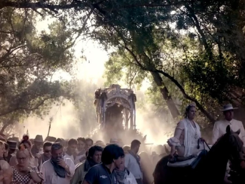 Celebración tradicional con procesión y caballos en un entorno boscoso.
