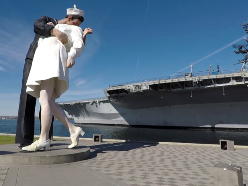 Estatua de un marinero besando a una mujer en frente de un buque de guerra en San Diego, California.