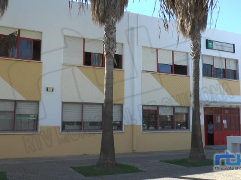 Fachada de un edificio con ventanas y palmeras, con el logo de RTV Municipal de Chipiona en la esquina inferior derecha.