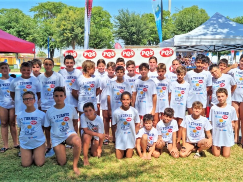 Equipo de jóvenes en camisetas blancas con el texto 'I Torneo PQS CW 2H' posando juntos en un evento al aire libre.