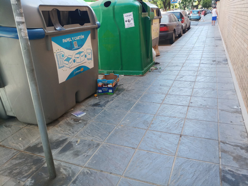 Contenedores de reciclaje en una acera urbana.