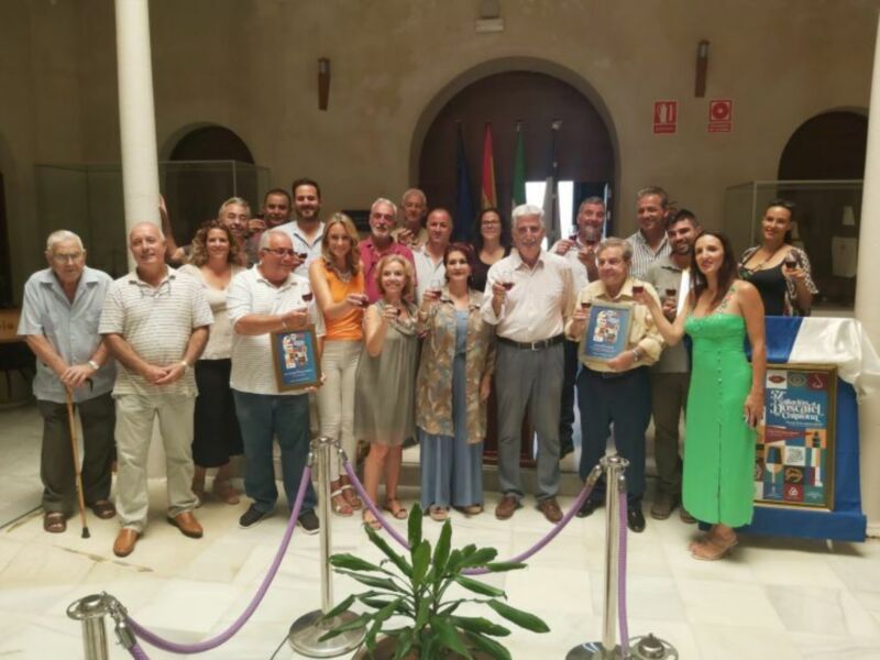 Celebración con miembros del equipo y premiación en un evento cultural.