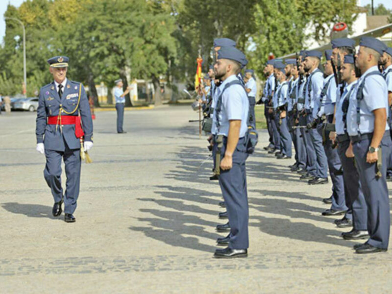 Un oficial inspecciona a una formación de soldados en uniforme durante una ceremonia militar al aire libre.