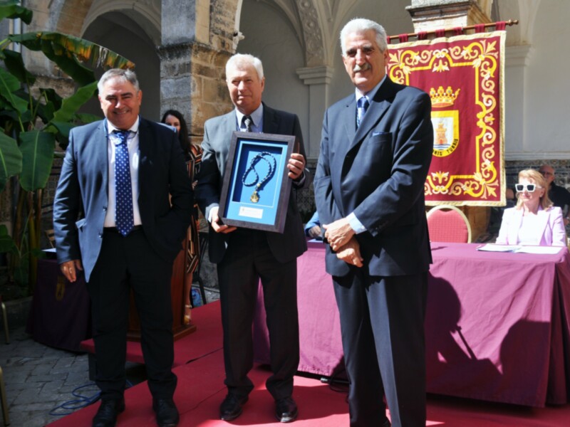 Entrega de una medalla honorífica en un evento formal en un patio histórico.