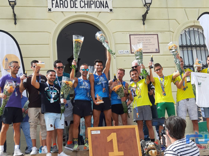 Equipo ganador celebrando en el podio de la carrera en Faro de Chipiona.