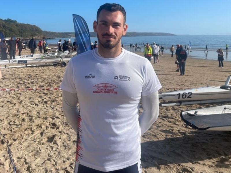 Atleta de remo en la playa, listo para competir en el Club de Remo Guadalquivir '86.