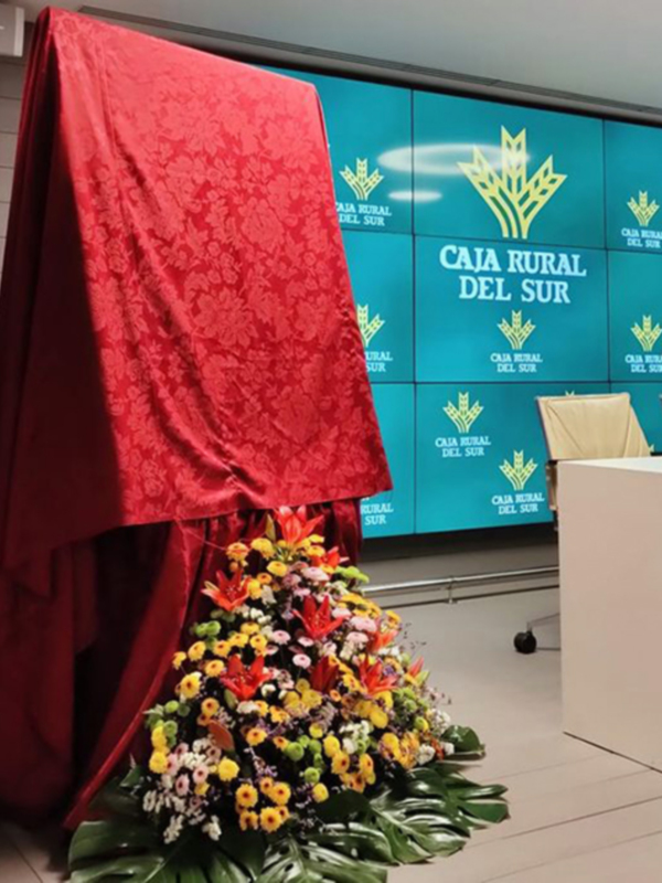 Inauguración de Caja Rural del Sur con flores y pantalla LED