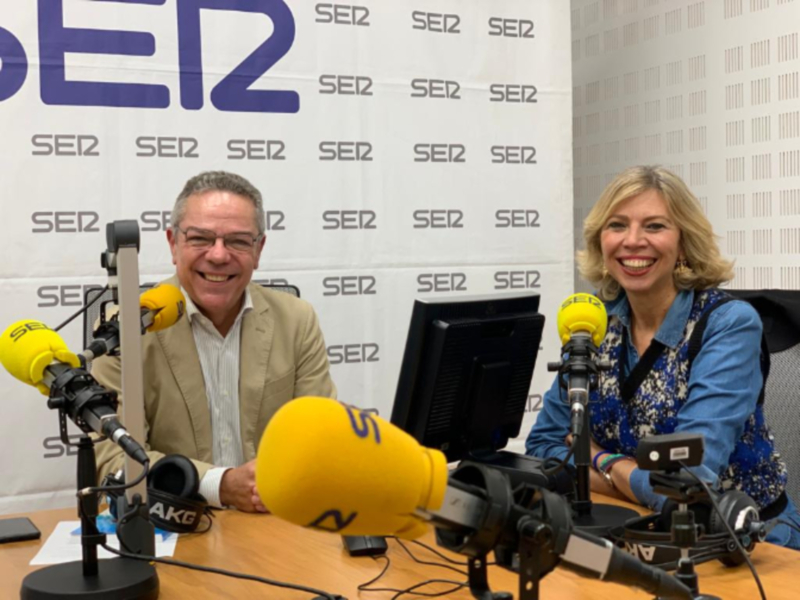 Entrevista en el estudio de radio SER2, con dos presentadores sonrientes en un ambiente profesional.