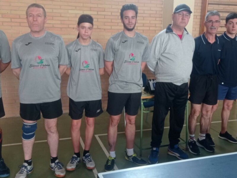 Equipo de tenis de mesa en una cancha deportiva.