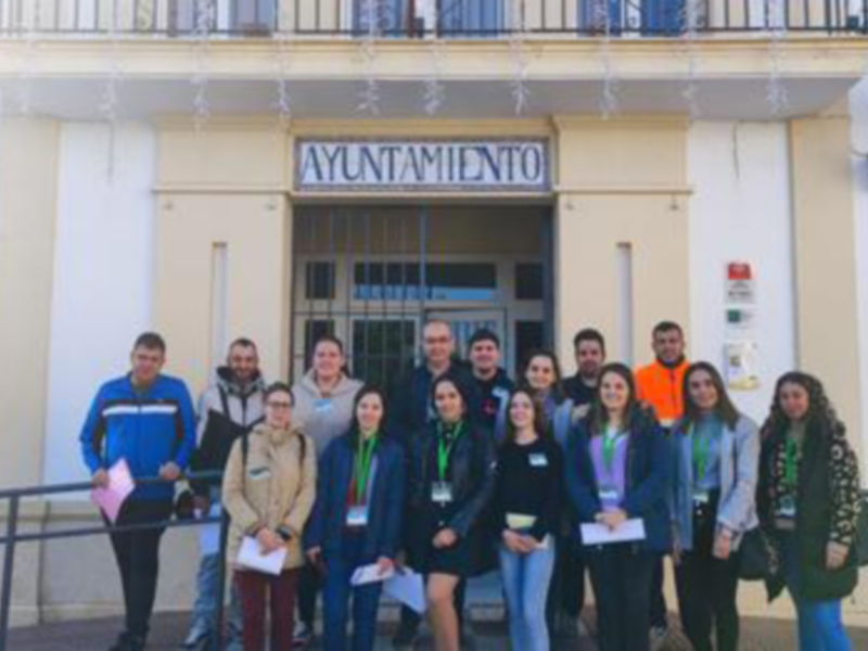 Equipo de profesionales posa frente al Ayuntamiento, con lentes y documentación, probablemente en una reunión o evento oficial.