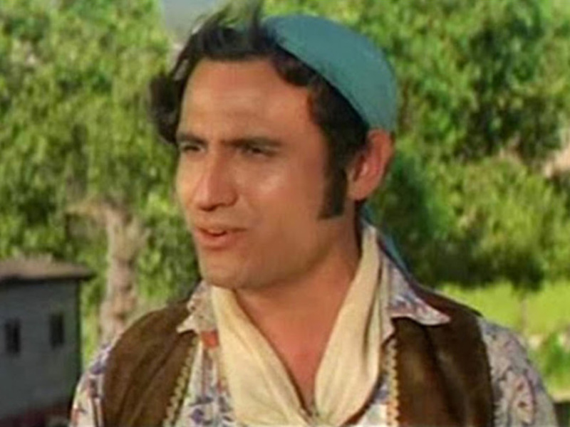 Personaje con sombrero y chaqueta, fondo rural con árboles y animales.