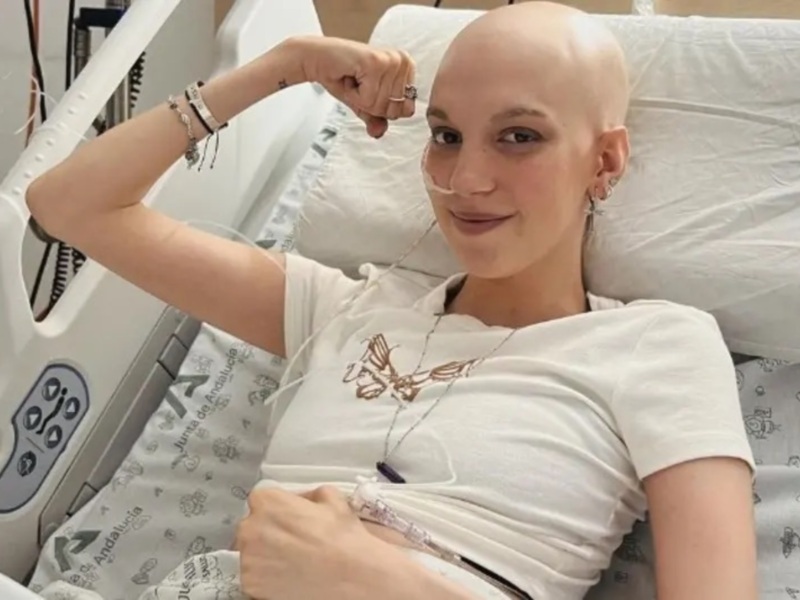 Persona con cáncer mostrando fuerza y optimismo en el hospital.