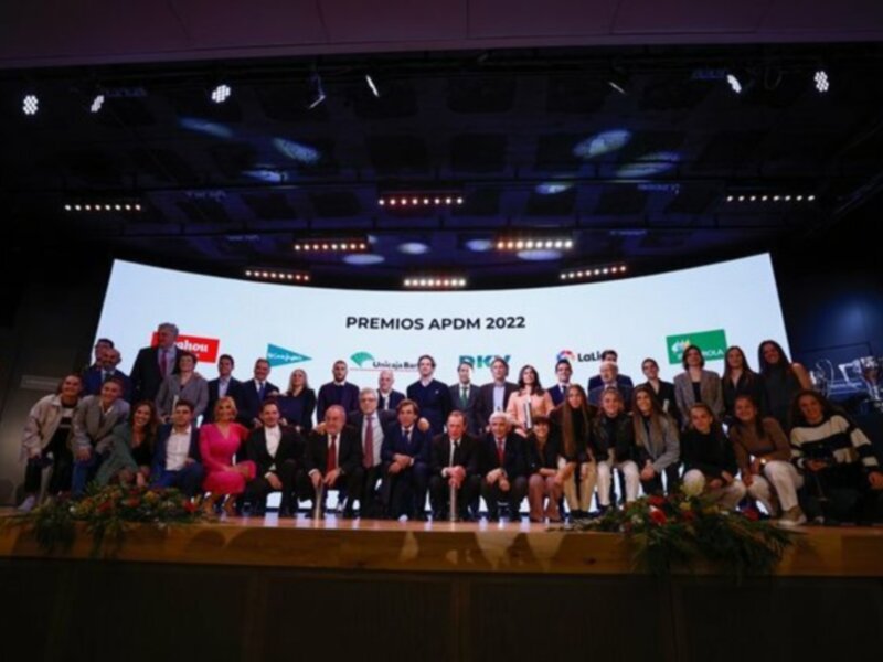 Premios APDM 2022: Celebración de logros en un evento formal con un grupo multitudinario en un escenario iluminado.